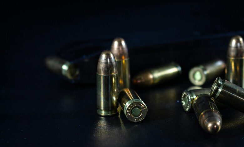 Detailed macro shot of bullets lying on a dark surface, emphasizing texture and shine.