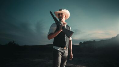 Dramatic portrait of a cowboy with shotgun in San Antonio at nightfall.