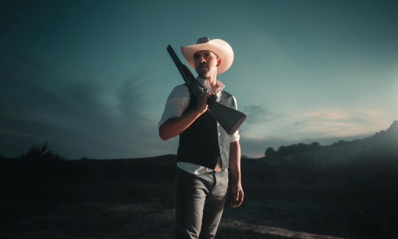 Dramatic portrait of a cowboy with shotgun in San Antonio at nightfall.