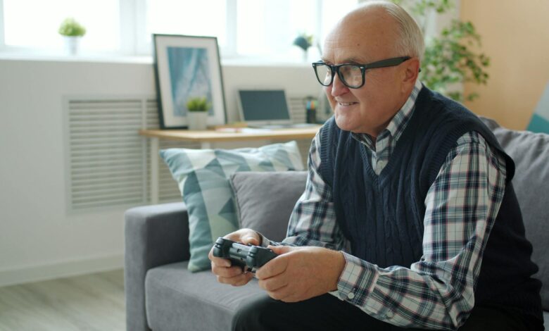Senior man enjoys gaming on a cozy couch at home, creating leisure vibes.