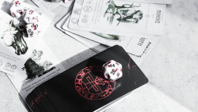 A collection of tarot cards and gaming dice on a tabletop, featuring mystical illustrations.