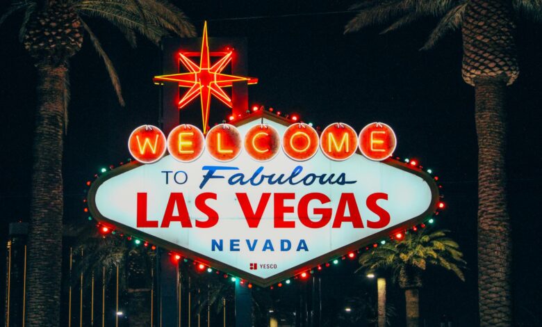 The iconic Welcome to Fabulous Las Vegas sign illuminated at night with palm trees in the background.
