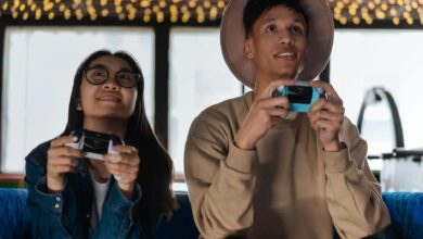 Two young adults immersed in an exciting gaming session indoors, enjoying leisure time.