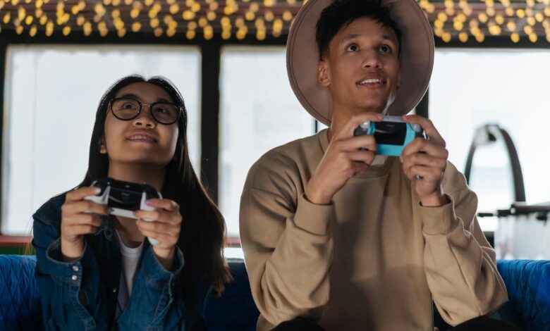 Two young adults immersed in an exciting gaming session indoors, enjoying leisure time.