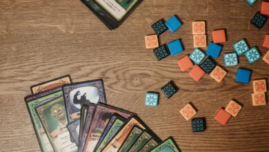 Top view of colorful board game cards and tokens on a wooden table, suggesting playful entertainment.