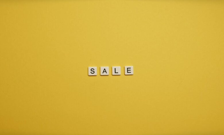 Single word 'SALE' spelled with tiles on a bright yellow background, ideal for advertising.
