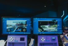 Immersive virtual reality gaming experience with dual screens and VR headsets, featuring driving simulations.
