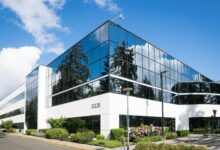 Contemporary office building in Redmond with reflective glass and lush greenery, captured on a sunny day.