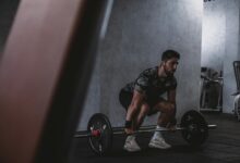 Man lifting weights in gym, displaying strength and focus. Ideal for fitness and training themes.