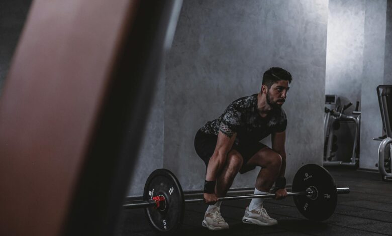 Man lifting weights in gym, displaying strength and focus. Ideal for fitness and training themes.