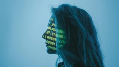 Silhouette of a woman with binary code projected on her face in a digital concept setting.