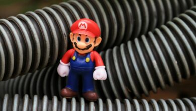 Close-up of a Super Mario toy figure standing among coiled plastic tubes.