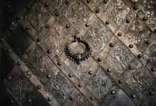 Close-up of a detailed metal door in Nuremberg, Germany displaying ornate medieval designs and a circular handle.