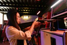 Teenage girl having fun playing a shooting game at an arcade, representing youthful playfulness.