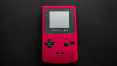 Close-up of a red Nintendo Game Boy Color on a dark backdrop, showcasing retro gaming nostalgia.
