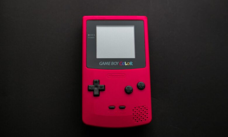 Close-up of a red Nintendo Game Boy Color on a dark backdrop, showcasing retro gaming nostalgia.