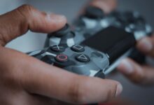 Detailed shot of hands gripping a camouflage game controller, perfect for gaming themes.