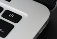 Detailed view of a power button on a sleek laptop, emphasizing technology design.