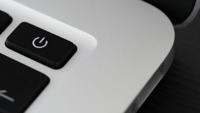 Detailed view of a power button on a sleek laptop, emphasizing technology design.
