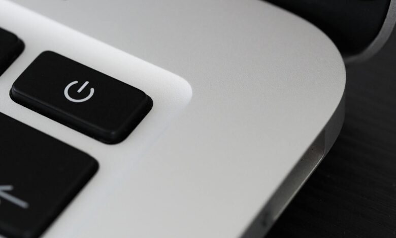 Detailed view of a power button on a sleek laptop, emphasizing technology design.