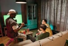 Three friends playing video games together in a cozy home setting.