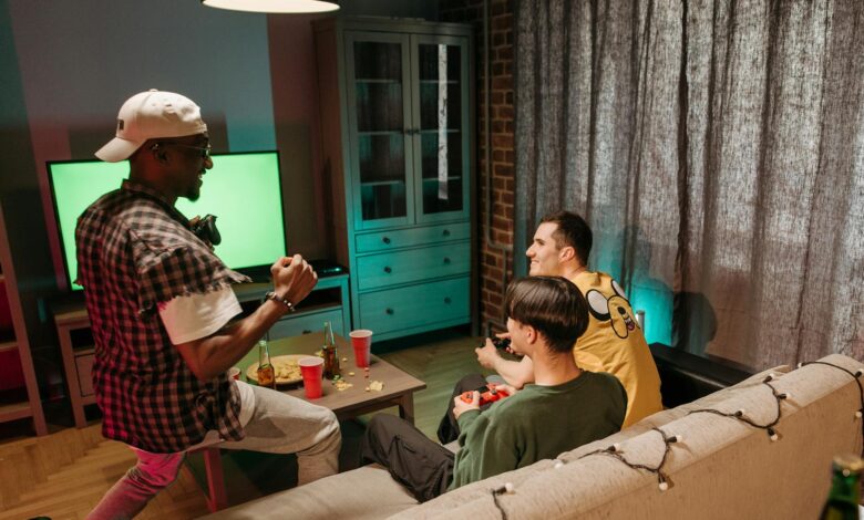 Three friends playing video games together in a cozy home setting.