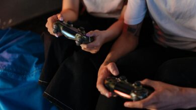 Two young adults gaming with controllers, captured in a cozy indoor setting.