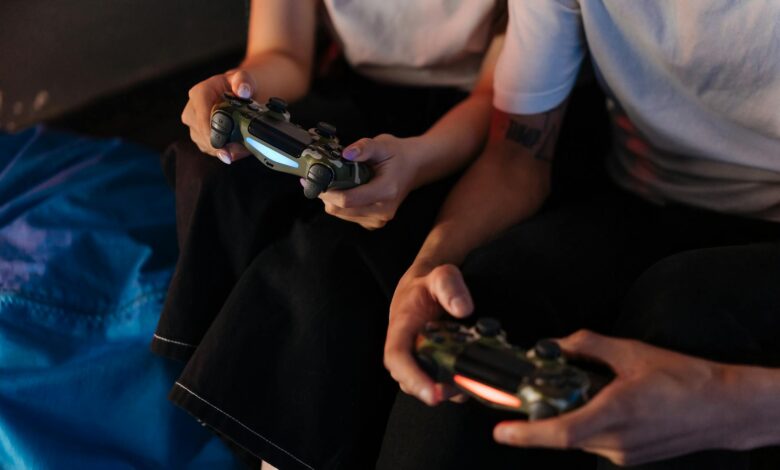 Two young adults gaming with controllers, captured in a cozy indoor setting.