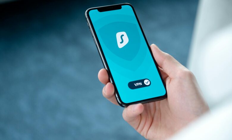 A hand holding a smartphone displaying a VPN app screen for secure online browsing.