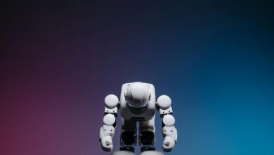 White robot in a bowing pose against a gradient studio background.