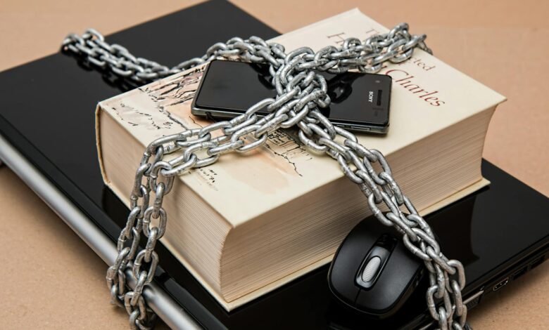 Chain-locked book, phone, and laptop symbolizing digital and intellectual security.