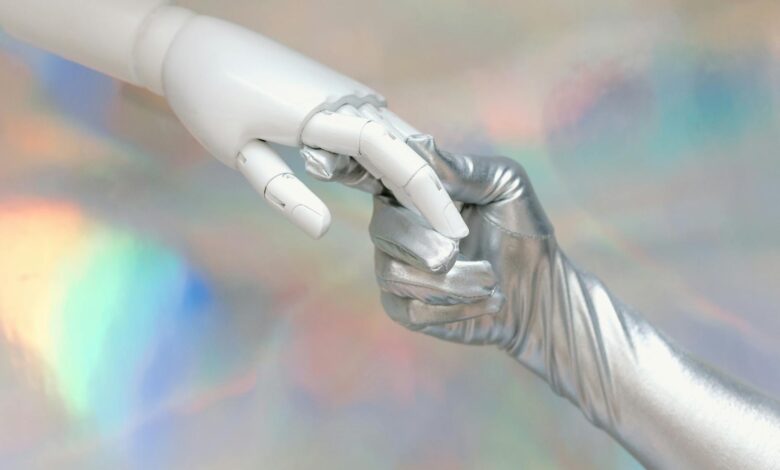 Close-up of a robot hand and silver-gloved hand touching, symbolizing human-robot connection.