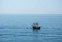 A majestic pirate ship sails across the calm waters of the Algarve coast.