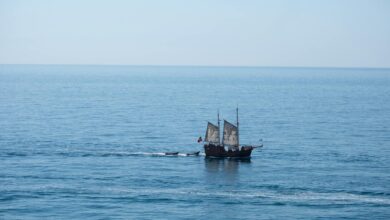 A majestic pirate ship sails across the calm waters of the Algarve coast.