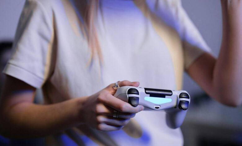Person playing video games with game controller in a relaxed setting.