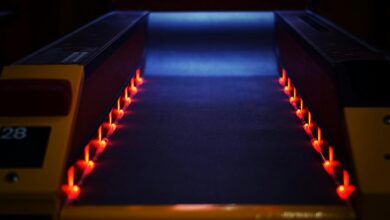 A vibrant neon-lit bowling lane creating a dynamic and dark atmosphere indoors.