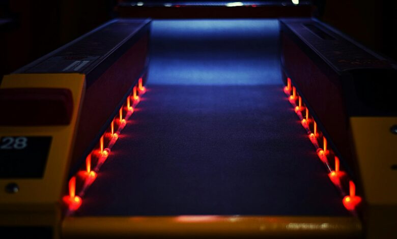 A vibrant neon-lit bowling lane creating a dynamic and dark atmosphere indoors.
