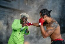 Intense moment of two cosplayers engaged in a dramatic fighting scene.