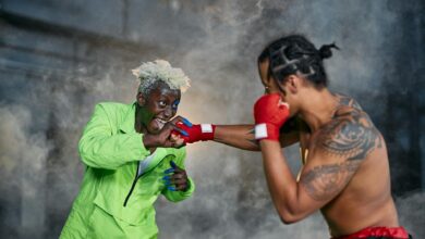 Intense moment of two cosplayers engaged in a dramatic fighting scene.