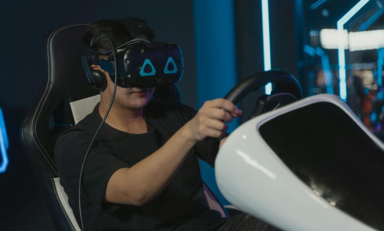 Man engaging in immersive virtual gaming with VR headset and steering wheel setup indoors.