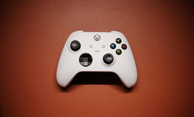 White Xbox controller isolated on a red background with shadows.