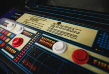 Close-up of a vintage arcade game control panel with colorful buttons and instructions.