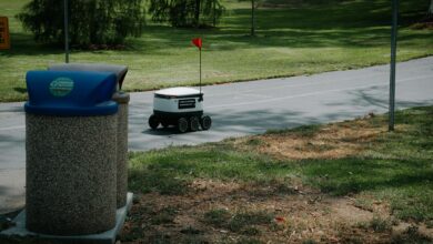Autonomous delivery robot on a park pathway, showcasing modern technology in a natural outdoor setting.