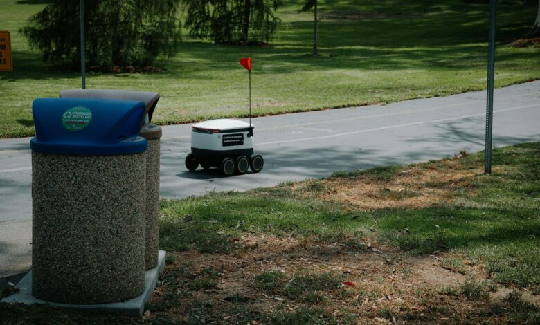 Autonomous delivery robot on a park pathway, showcasing modern technology in a natural outdoor setting.