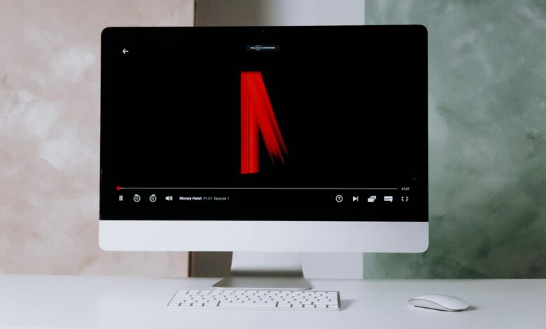Modern desktop setup featuring streaming on a sleek monitor with keyboard and mouse.