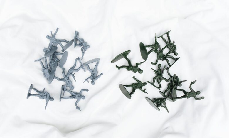 Colorful army toy figures arranged on a white cloth in aerial view.