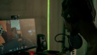 Focused gamer with headset playing a video game on a desktop computer indoors.