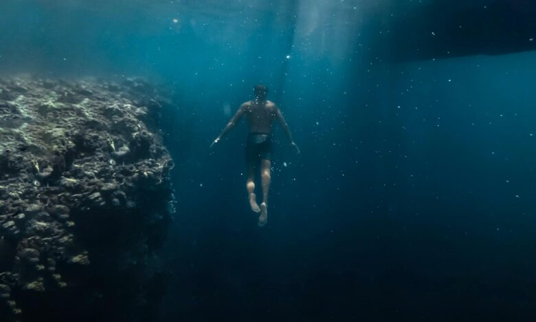 A diver explores vibrant coral reef underwater, capturing the tranquility and mystery of the ocean.