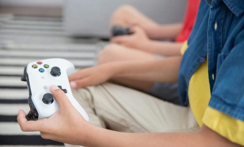 Two children playing video games with controllers, indoors, showcasing fun and technology.