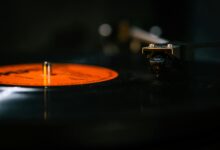 Detailed still life of a turntable needle on a spinning vinyl record, capturing the analog music experience.